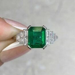 Five baguette cut diamonds put on both sides of this 1.60 carat authentic emerald prong set