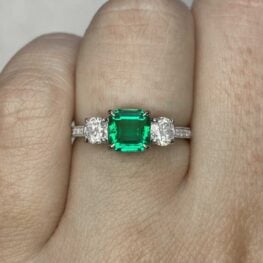 greendale engagement ring with diamonds next to emerald stone