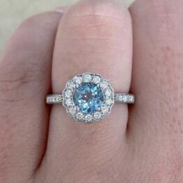 A charming cluster ring featuring a natural round aquamarine weighing 0.75 carats